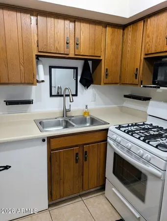 a kitchen with granite countertop a sink stove and cabinets