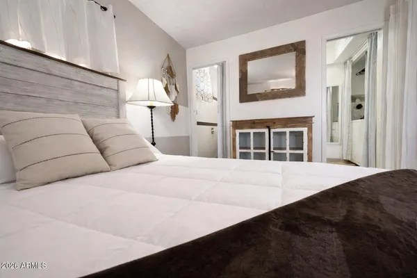 a bedroom with a large bed and a chandelier