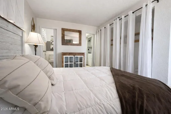 a bedroom with a bed and a mirror