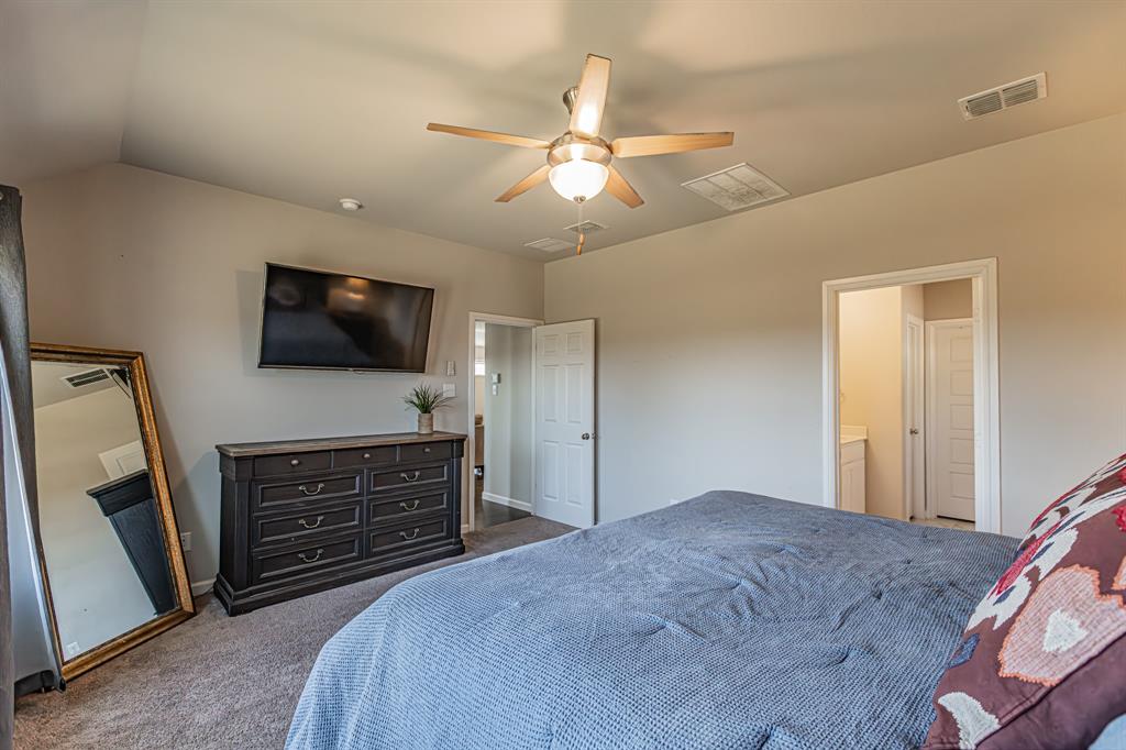 10269 Hanks Creek Road Fort Worth, TX 76126 - Photo 18 of 40 a bedroom with a bed and a flat tv screen on dresser