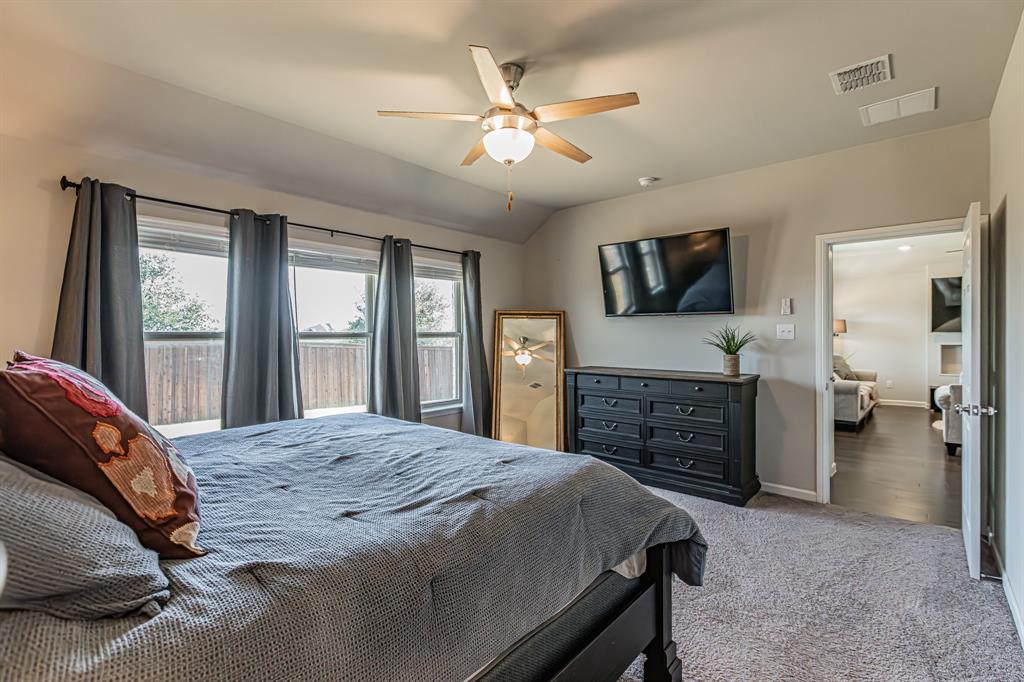 10269 Hanks Creek Road Fort Worth, TX 76126 - Photo 19 of 40 a spacious bedroom with a bed and a flat screen tv