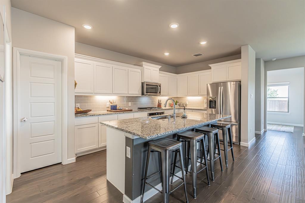 10269 Hanks Creek Road Fort Worth, TX 76126 - Photo 25 of 40 a kitchen with stainless steel appliances granite countertop a table chairs sink refrigerator and cabinets