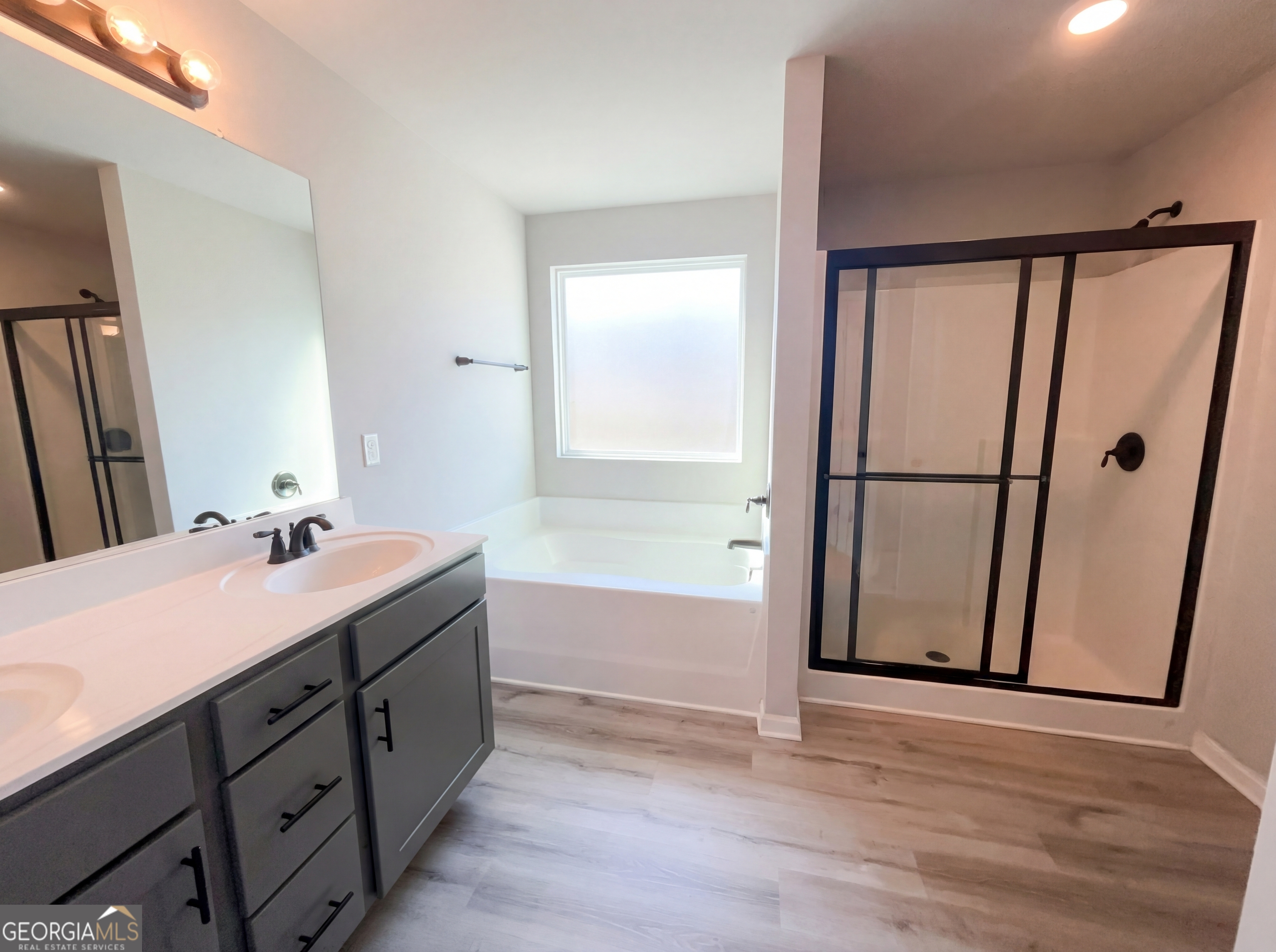 981 Fellowship Road, Unit 108 Fairburn, GA 30213 - Photo 19 of 21 a bathroom with a double vanity sink a mirror and a bathtub