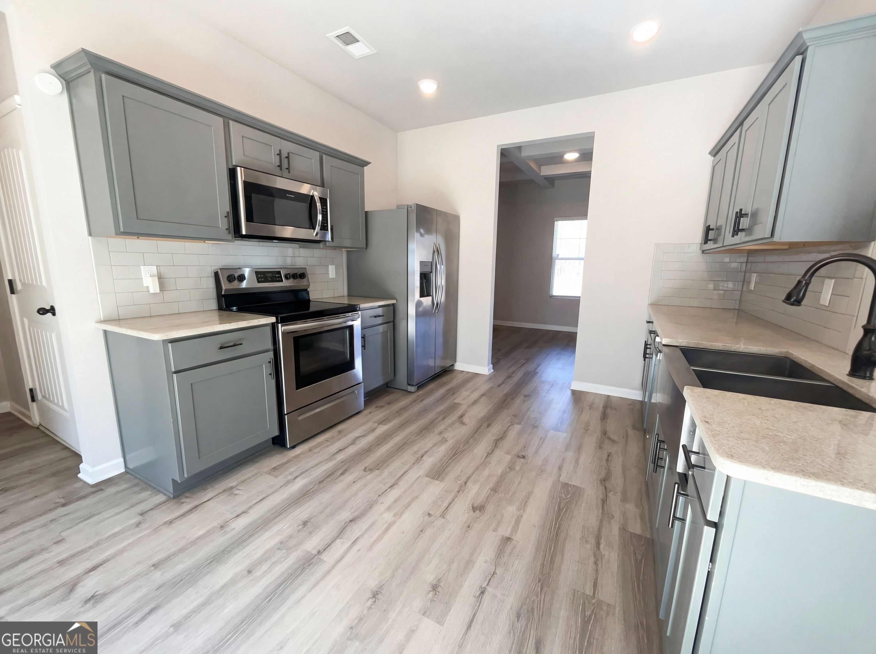 981 Fellowship Road, Unit 108 Fairburn, GA 30213 - Photo 2 of 21 a kitchen with a sink wooden floor and stainless steel appliances