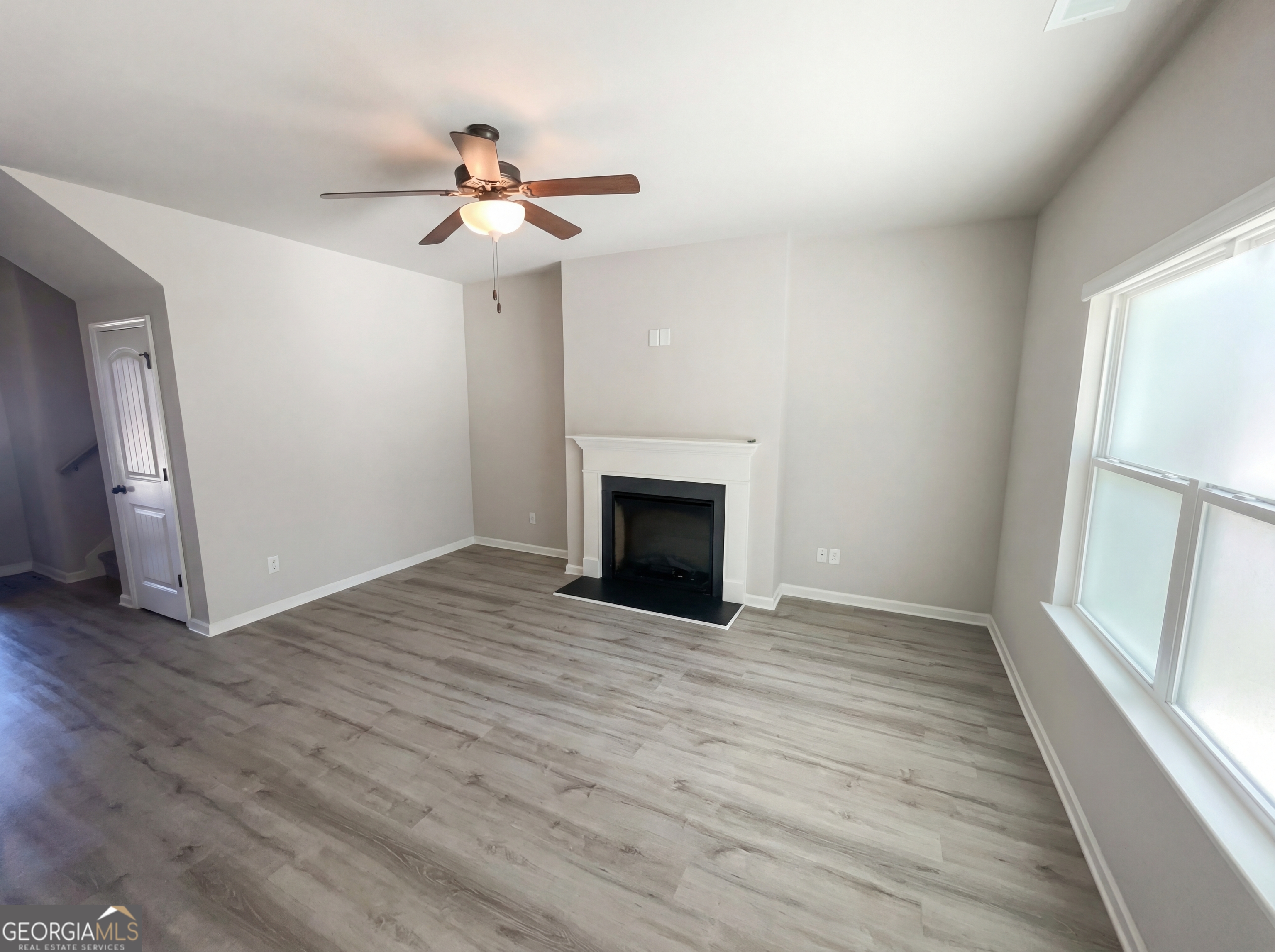 981 Fellowship Road, Unit 108 Fairburn, GA 30213 - Photo 3 of 21 a view of empty room with wooden floor and fireplace