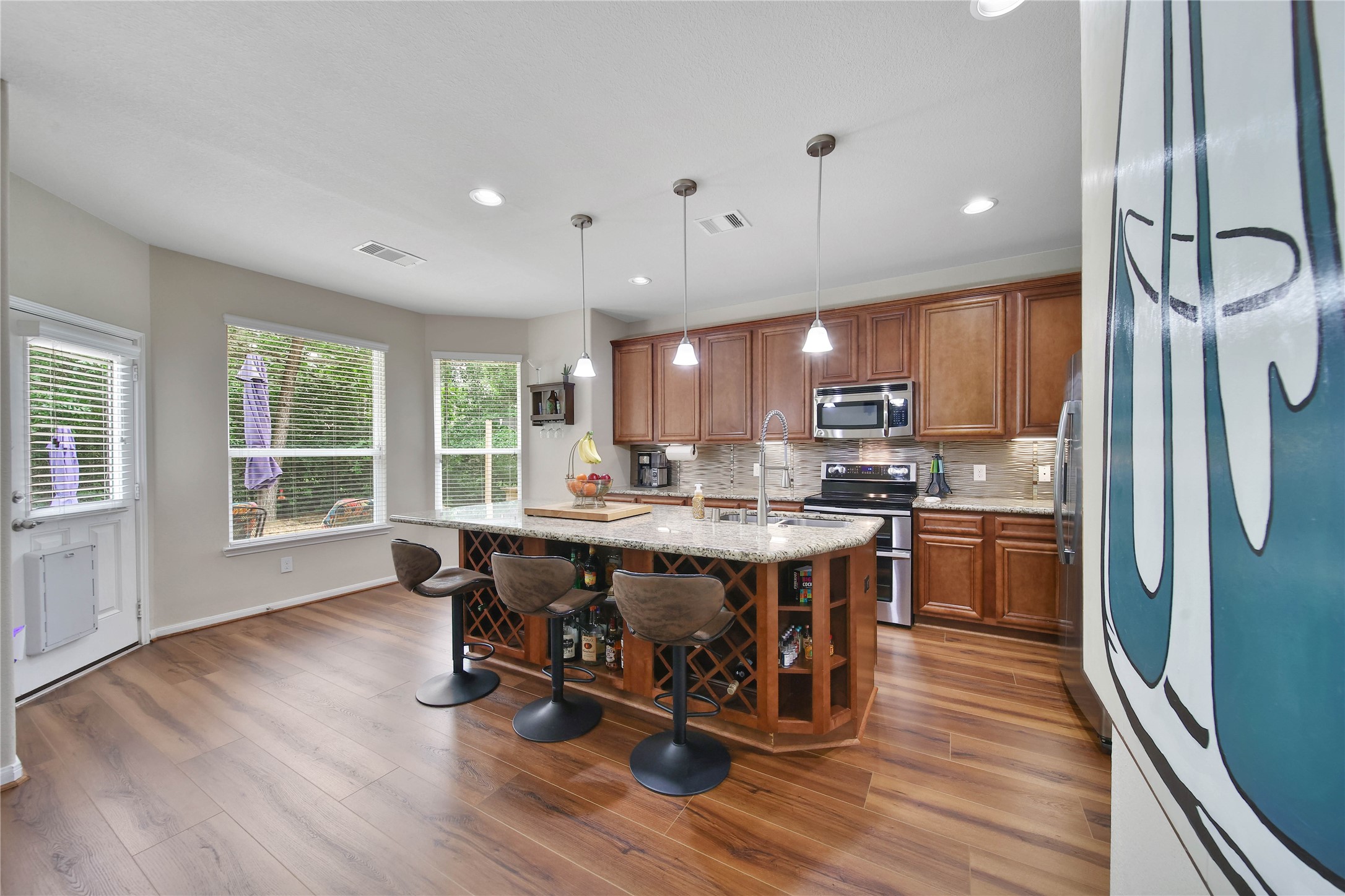 9223 Wapiti Trail Conroe, TX 77303 - Photo 16 of 45 a kitchen with stainless steel appliances granite countertop a refrigerator a stove top oven a sink dishwasher and cabinets with wooden floor