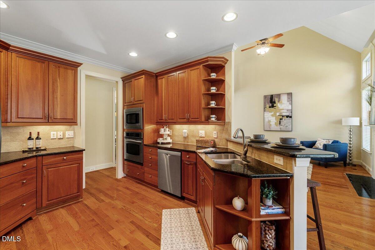 3628 Jamison Park Drive Apex, NC 27539 - Photo 15 of 60 a kitchen with stainless steel appliances granite countertop a sink and wooden cabinets