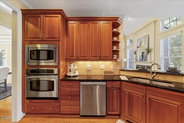 a kitchen with granite countertop a sink and stainless steel appliances
