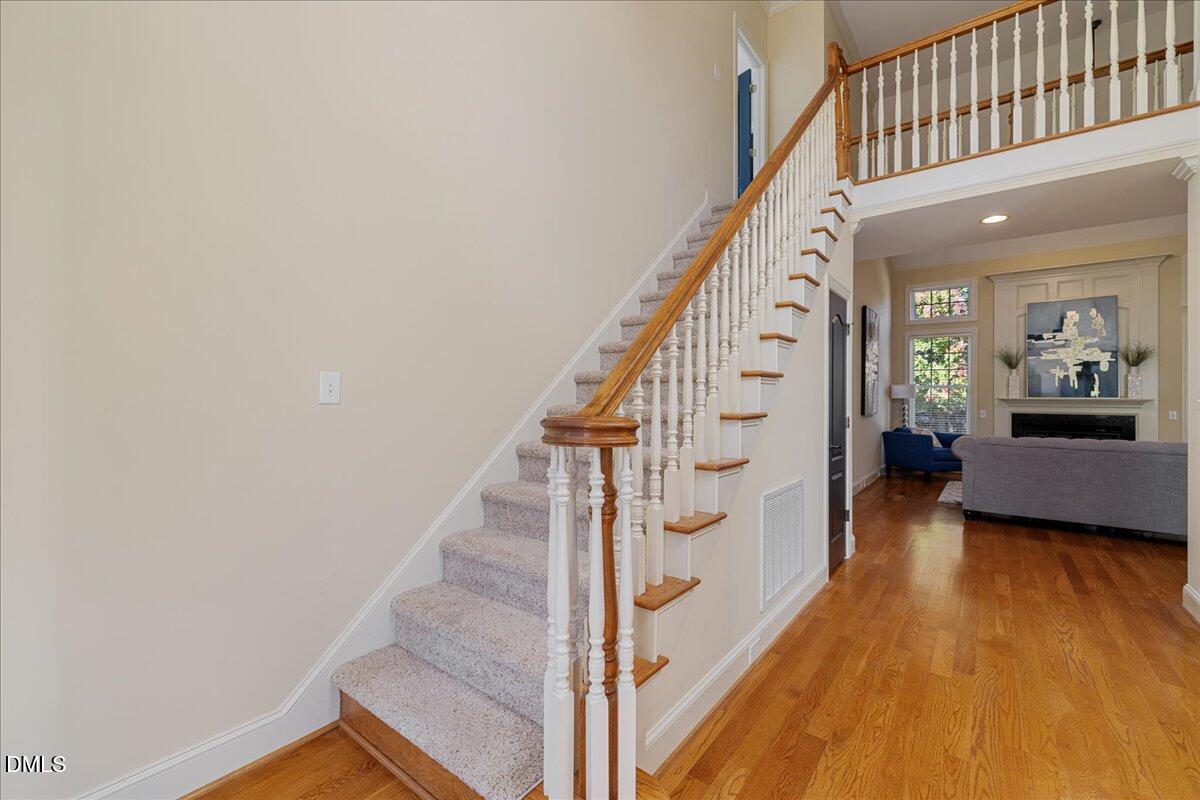 3628 Jamison Park Drive Apex, NC 27539 - Photo 31 of 60 a view of a hallway with wooden floor and staircase