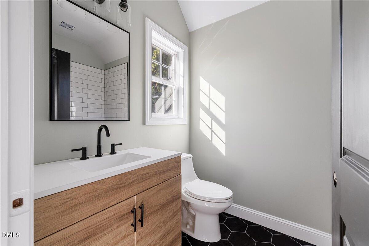 3628 Jamison Park Drive Apex, NC 27539 - Photo 35 of 60 a bathroom with a sink a toilet and a window