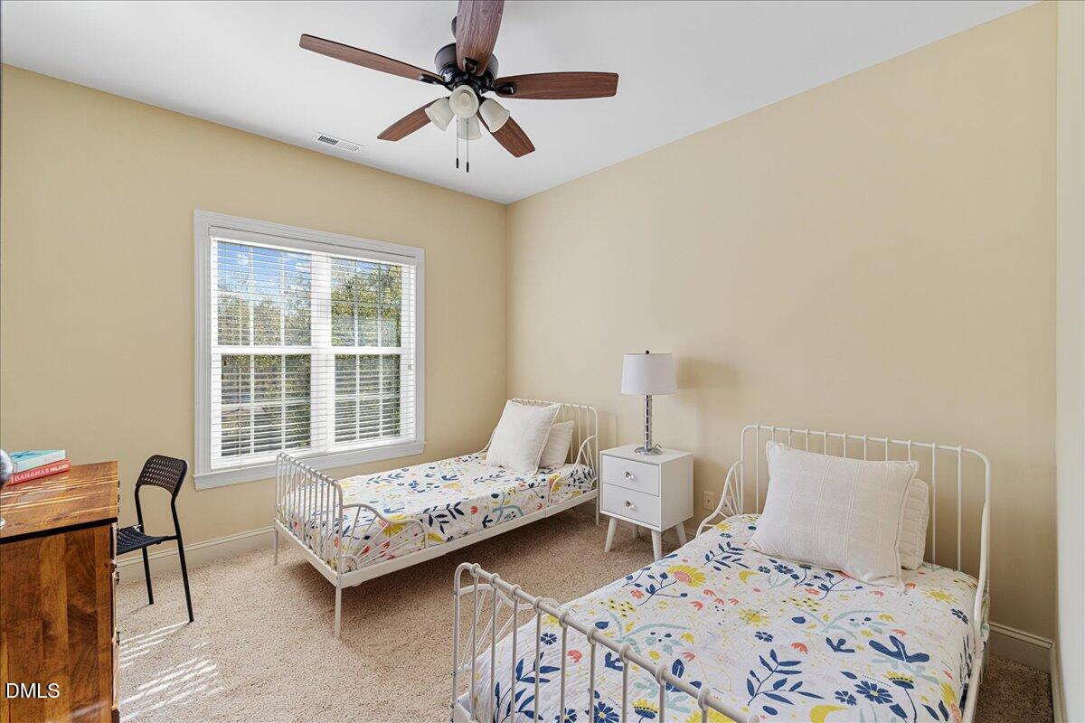 3628 Jamison Park Drive Apex, NC 27539 - Photo 37 of 60 a bedroom with a bed and a table in it