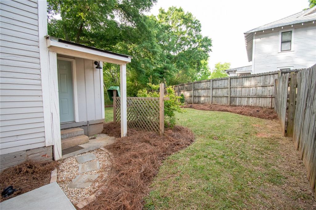 702 Radford Street Monroe, GA 30655 - Photo 44 of 49 a view of a backyard with a small cabin and wooden fence