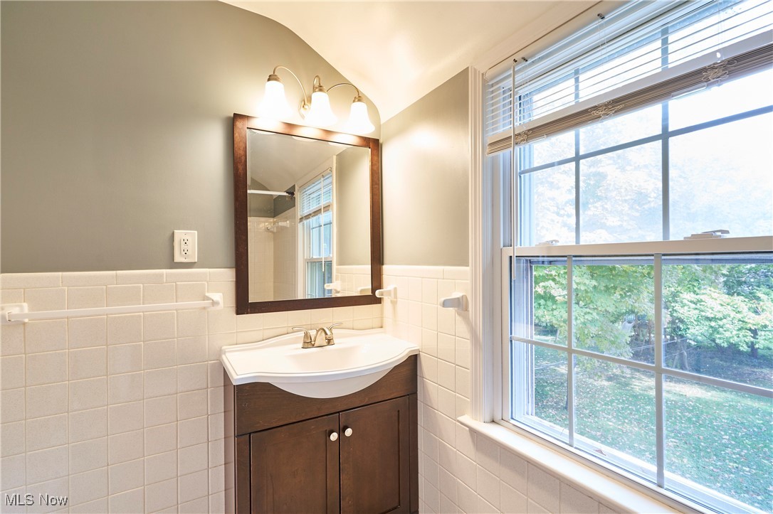 1111 Ford Road Lyndhurst, OH 44124 - Photo 17 of 27 Bathroom with vanity, tile walls, and a wealth of natural light