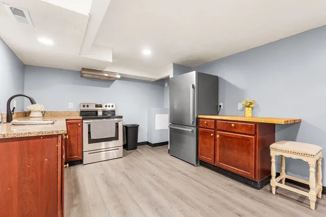 a kitchen with stainless steel appliances a stove a refrigerator and wooden cabinets