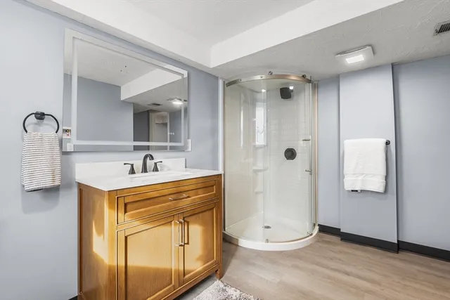 a bathroom with a sink a mirror and shower