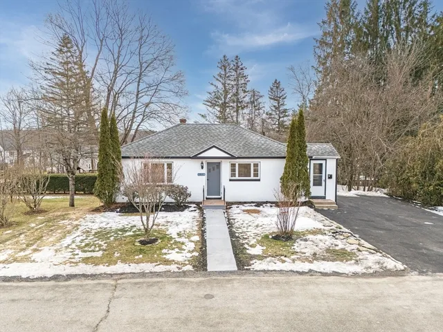 a front view of a house with a yard covered in snow