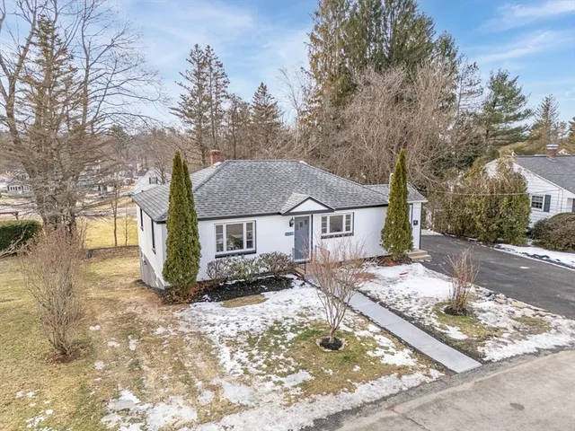 a front view of a house with a yard covered in snow