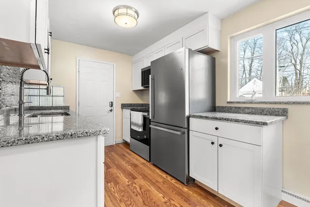 a kitchen with granite countertop a refrigerator and a sink