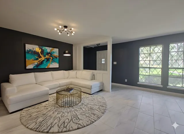 a living room with furniture a floor to ceiling window and a flat screen tv