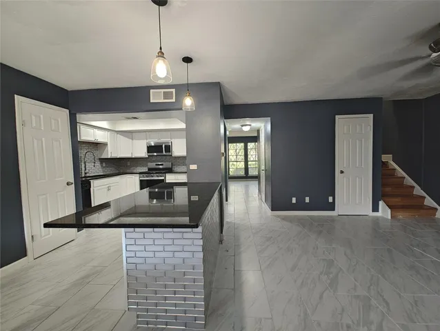 a kitchen with stainless steel appliances granite countertop a sink a stove and a refrigerator