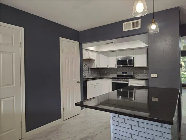 a kitchen with stainless steel appliances granite countertop a sink and cabinets