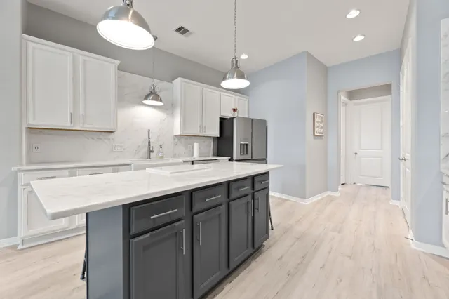 a kitchen with kitchen island a sink stainless steel appliances and cabinets