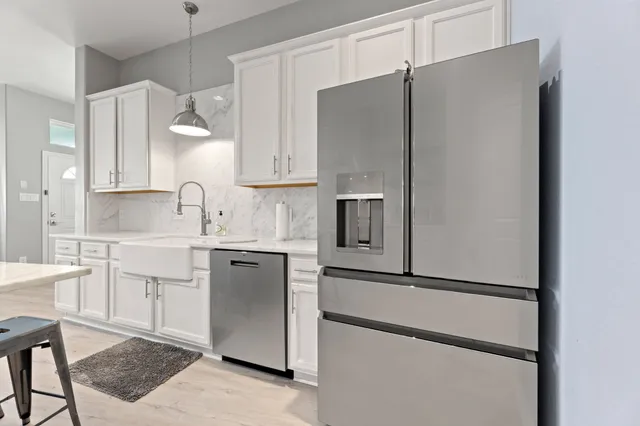 a kitchen with a refrigerator sink and cabinets