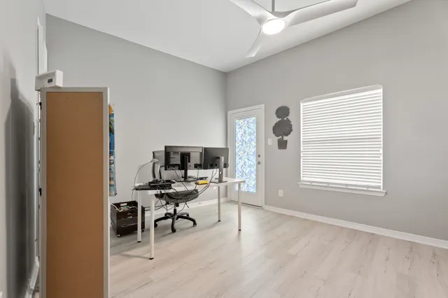 a view of a workspace with furniture and a window