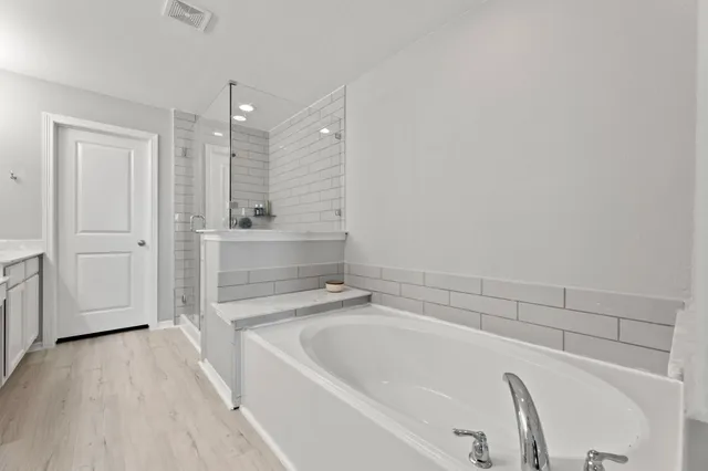 a spacious bathroom with a bathtub and a shower