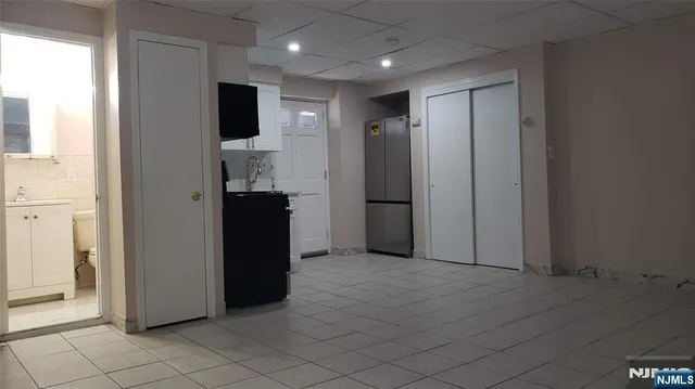 a view of hallway with furniture and a refrigerator