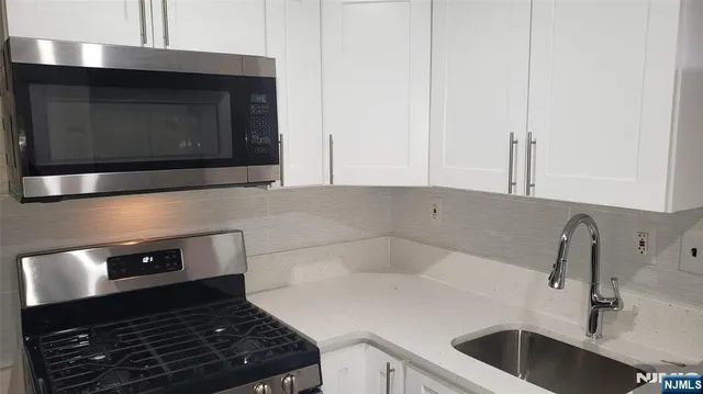 a kitchen with a sink stove and microwave