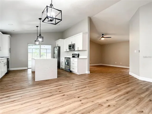 a view of a kitchen with wooden floor electronic appliances and wooden floor