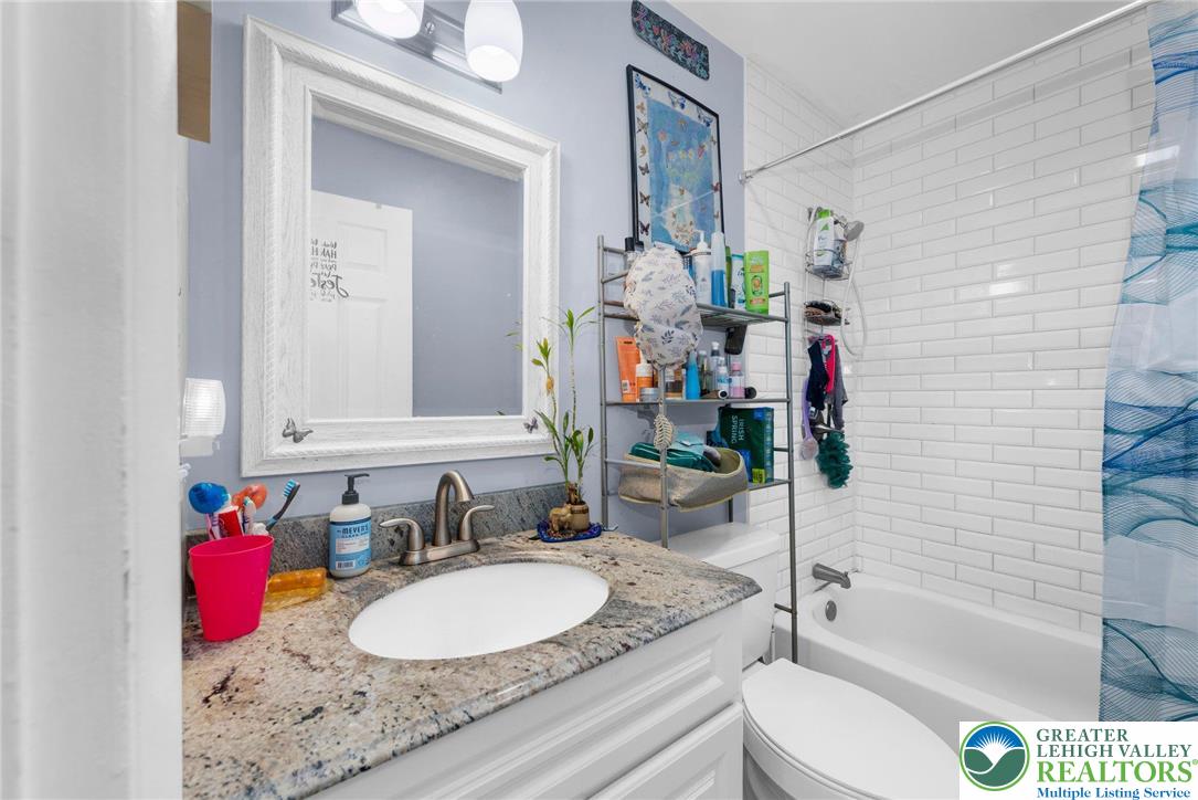 935 Marion Street Bethlehem, PA 18017 - Photo 9 of 20 a bathroom with a granite countertop sink mirror vanity bathtub and a shower