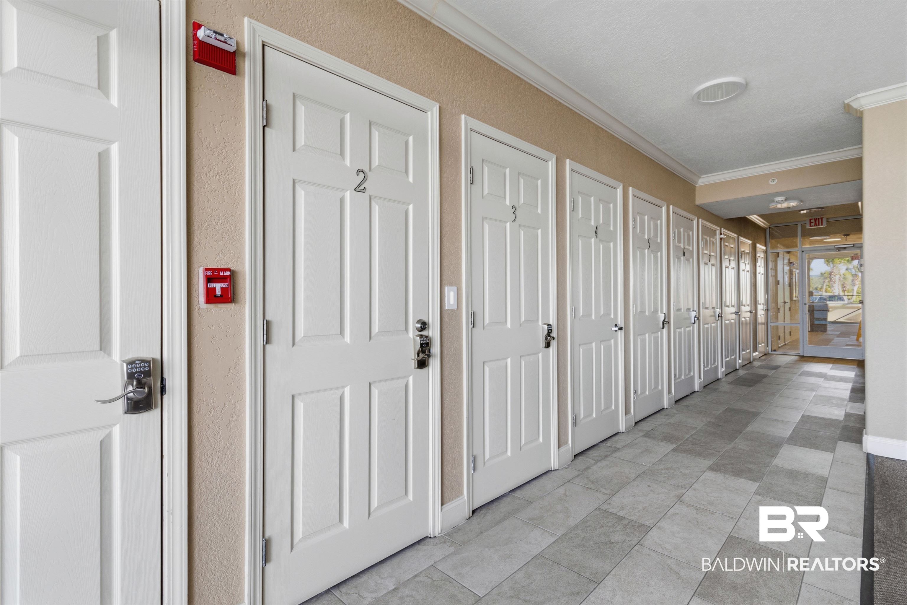 3564 Bayou Road, Unit 203 Orange Beach, AL 36561 - Photo 35 of 53 Corridor featuring paneled doors with unit numbers, crown molding, and neutral wall tones