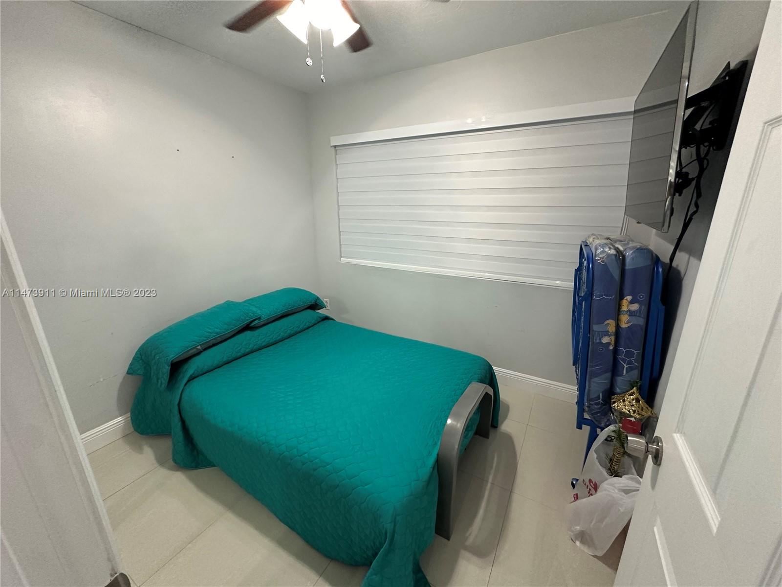 4610 Southwest 89th Place Miami, FL 33165 - Photo 19 of 52 a bedroom with a bed and a chandelier