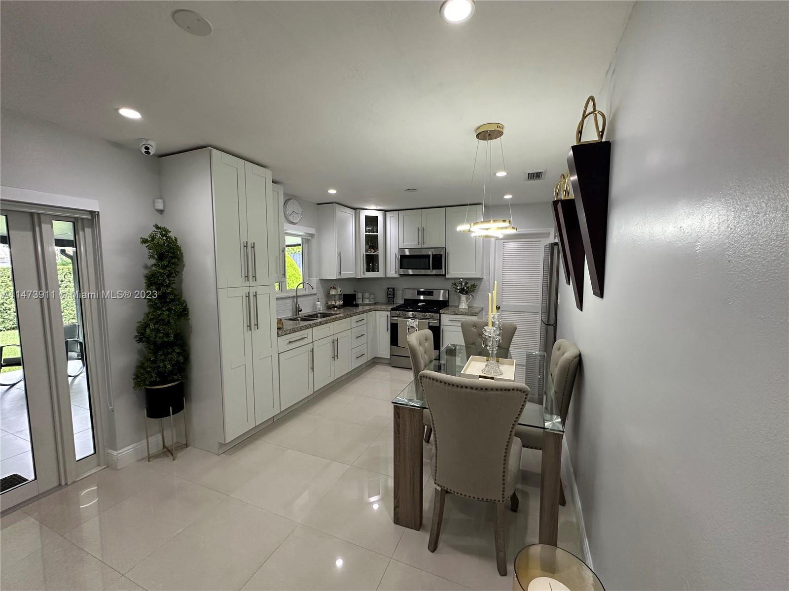 4610 Southwest 89th Place Miami, FL 33165 - Photo 23 of 52 a kitchen with refrigerator and chairs