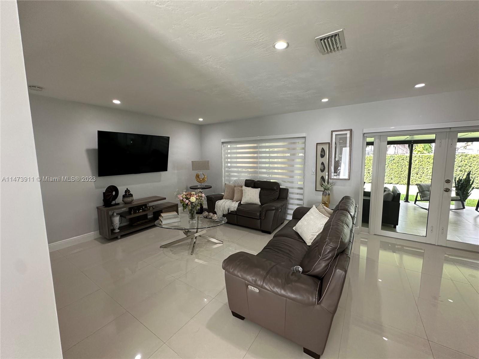 4610 Southwest 89th Place Miami, FL 33165 - Photo 25 of 52 a living room with furniture and a flat screen tv