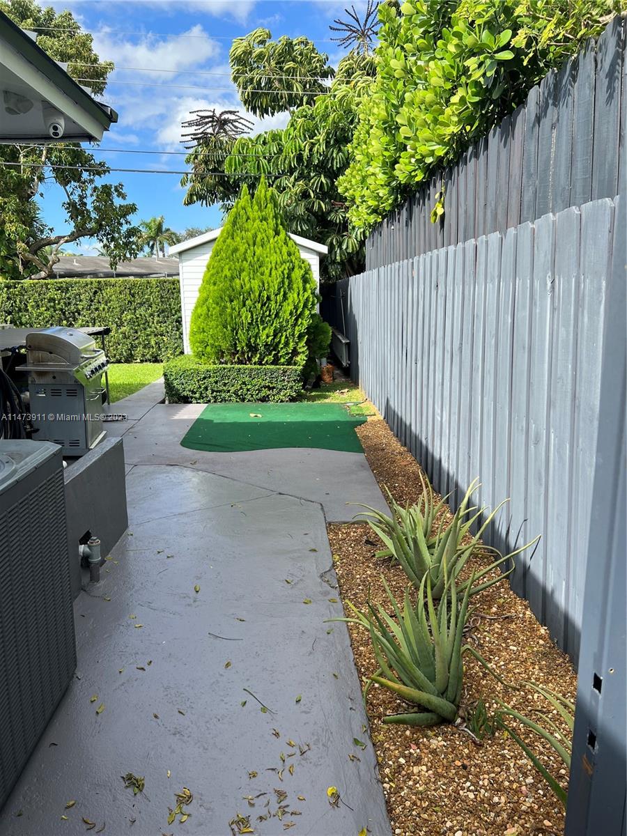 4610 Southwest 89th Place Miami, FL 33165 - Photo 33 of 52 a view of a backyard with plants and a bench
