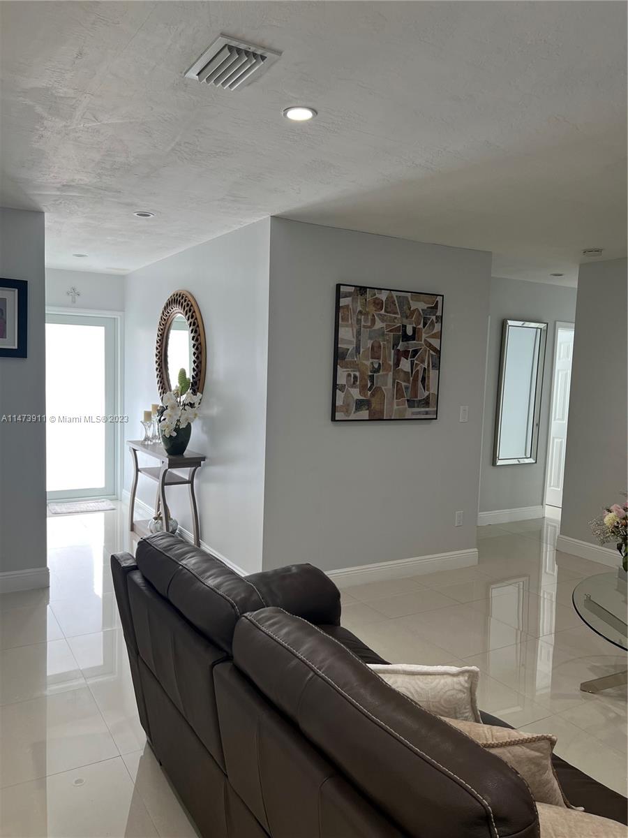 4610 Southwest 89th Place Miami, FL 33165 - Photo 41 of 52 a living room with a couch and a mirror