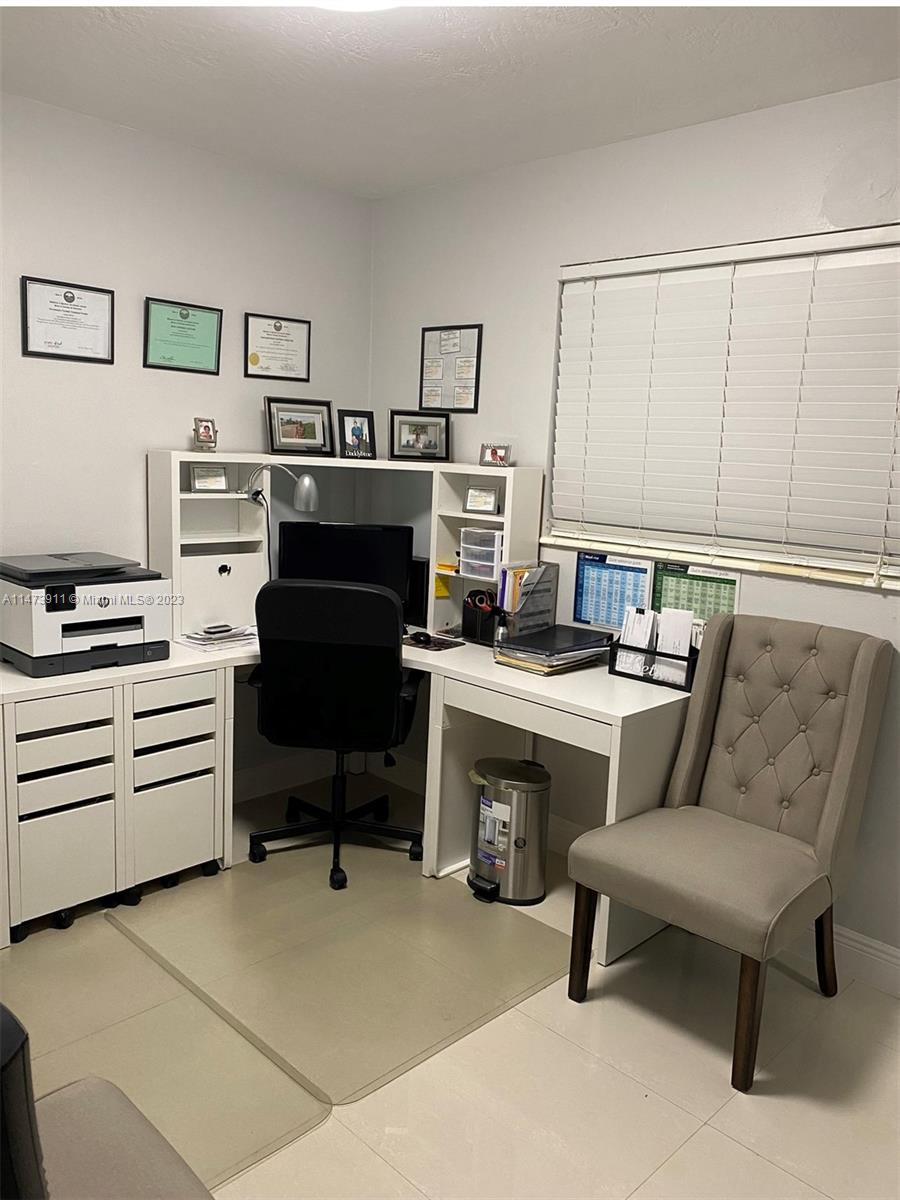 4610 Southwest 89th Place Miami, FL 33165 - Photo 49 of 52 a room with furniture a piano and a bookshelf