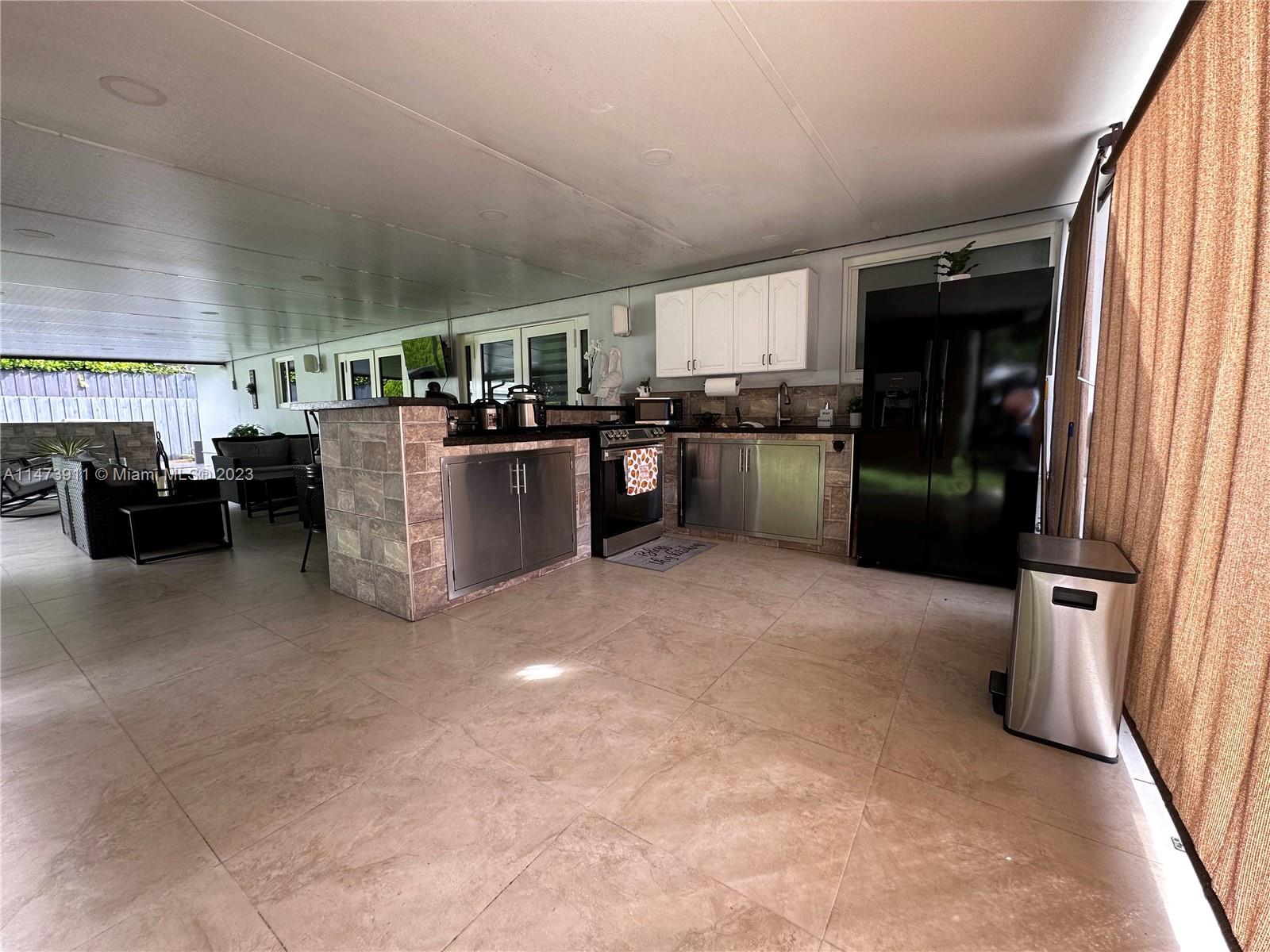 4610 Southwest 89th Place Miami, FL 33165 - Photo 5 of 52 a kitchen with a refrigerator and furniture
