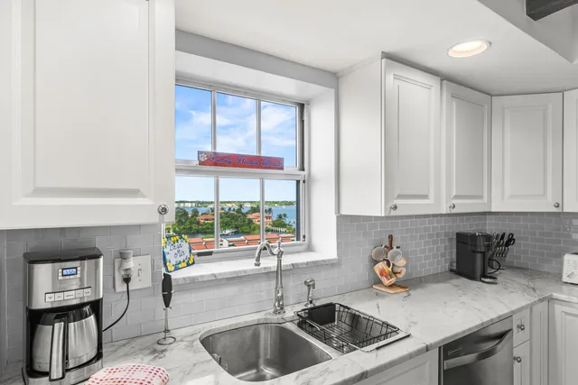 a kitchen with stainless steel appliances granite countertop a sink and a white cabinets