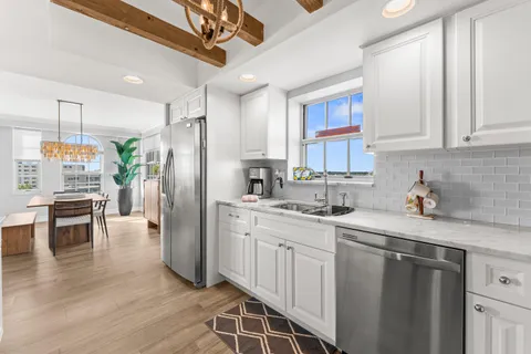 a kitchen with a sink stainless steel appliances and white cabinets