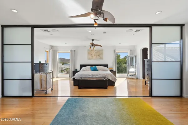a spacious bedroom with a bed and wooden floor
