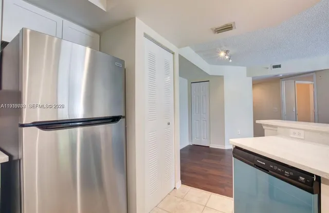 a kitchen with a refrigerator and a stove top oven