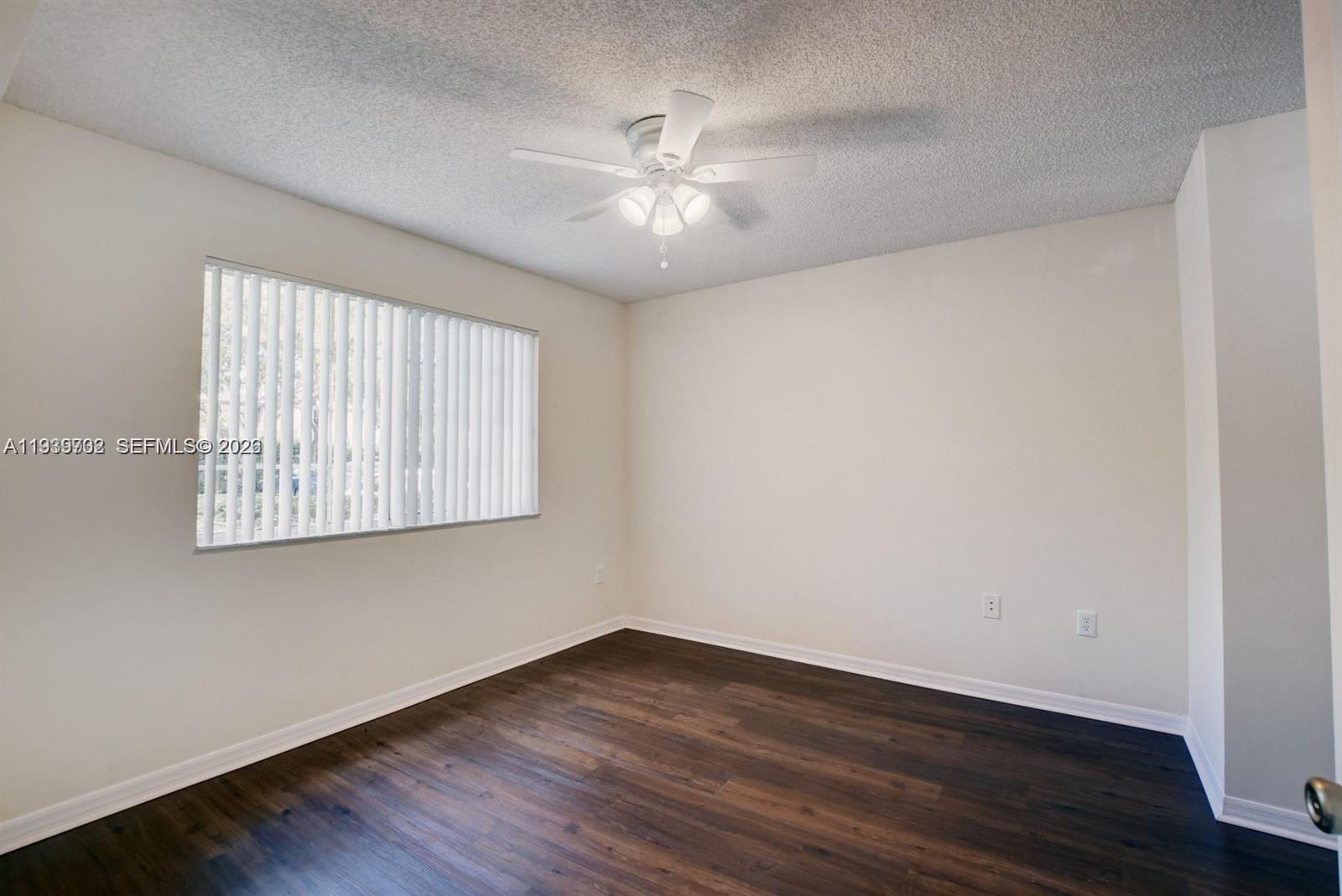 4159 Haverhill Road, Unit 1302 West Palm Beach, FL 33417 - Photo 6 of 19 wooden floor in an empty room with a window