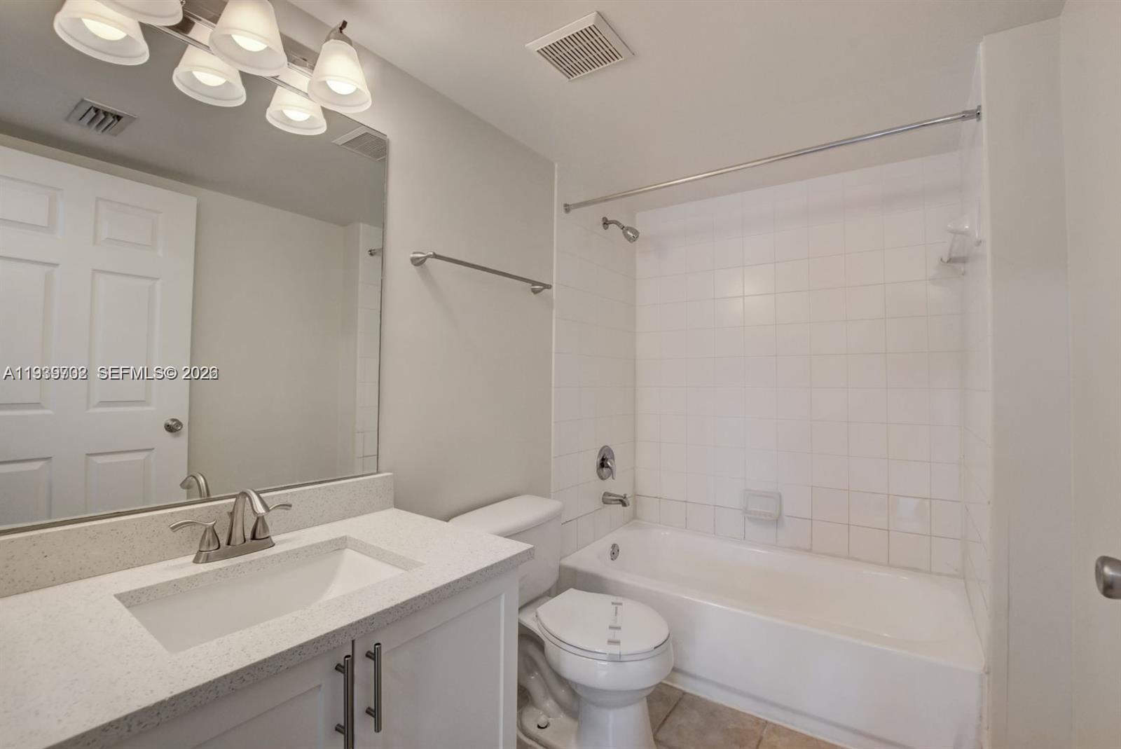 4159 Haverhill Road, Unit 1302 West Palm Beach, FL 33417 - Photo 9 of 19 a bathroom with a bathtub a sink a toilet and a mirror