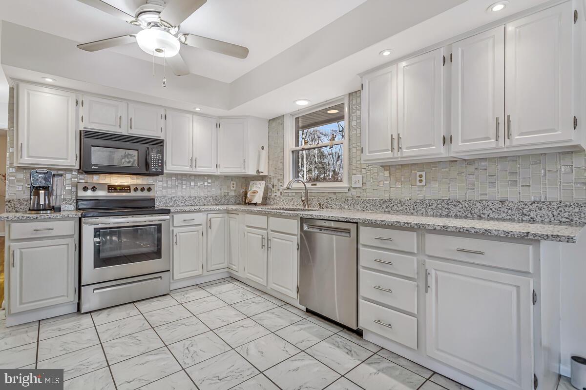 1921 Haven Lane Dunkirk, MD 20754 - Photo 17 of 64 a kitchen with granite countertop white cabinets white stainless steel appliances with a sink and dishwasher