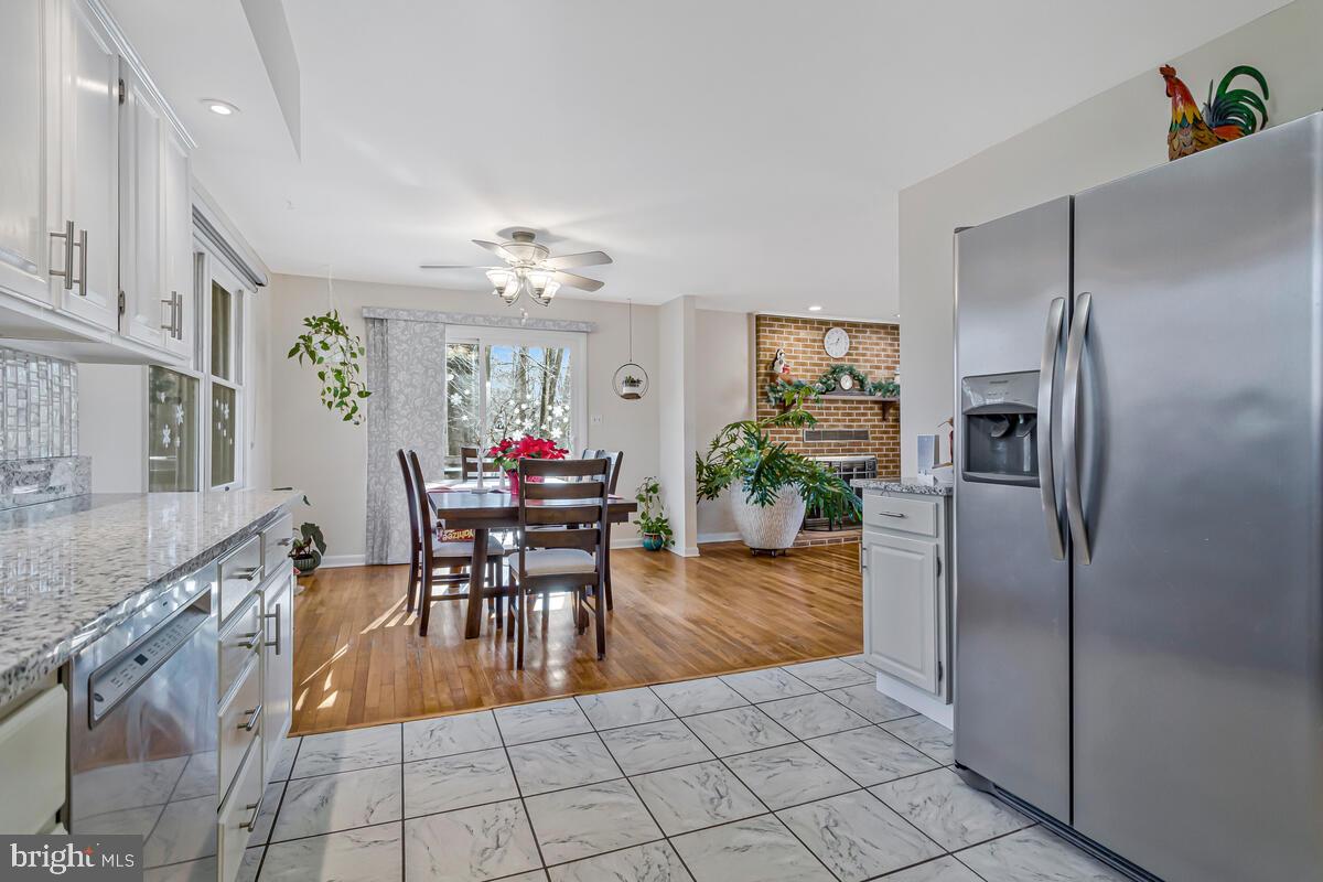 1921 Haven Lane Dunkirk, MD 20754 - Photo 19 of 64 a kitchen with granite countertop a refrigerator a stove a dining table and chairs