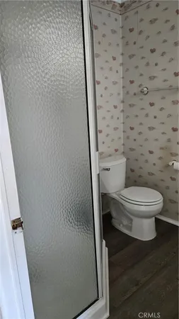 a white toilet sitting next to a shower